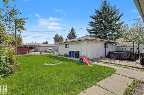 Expansive backyard featuring a concrete patio, detached garage, and mature landscaping - 4323 114B Street Nw, Edmonton, AB - Outdoor