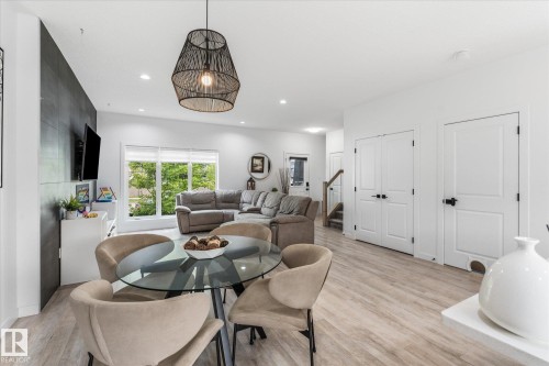 Open-concept living space with light wood-finish flooring, recessed lighting, and a contemporary pendant fixture - 9 Dillingham Avenue, Fort Saskatchewan, AB - Indoor