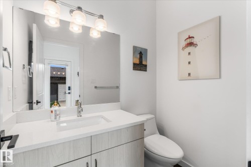 White floating vanity with a single basin sink, chrome faucet, and rectangular mirror - 9 Dillingham Avenue, Fort Saskatchewan, AB - Indoor Photo Showing Bathroom