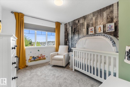 Expansive window, textured accent wall, light-colored carpeting, white trim, recessed lighting fixture - 9 Dillingham Avenue, Fort Saskatchewan, AB - Indoor Photo Showing Bedroom