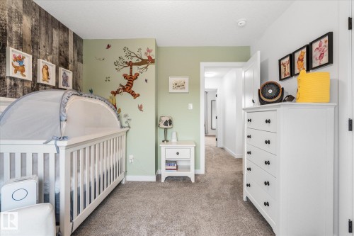 Wall with vertical wood paneling, light green painted walls, and textured carpeting - 9 Dillingham Avenue, Fort Saskatchewan, AB - Indoor Photo Showing Bedroom