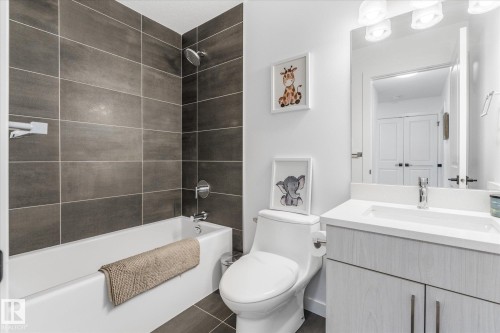 Full bath with a white soaking tub and shower featuring dark gray rectangular wall tile - 9 Dillingham Avenue, Fort Saskatchewan, AB - Indoor Photo Showing Bathroom