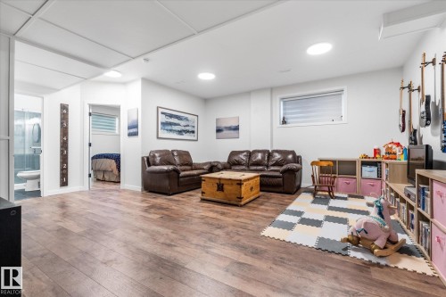 Finished basement with wood-finish flooring, recessed lighting, and a drop ceiling - 9 Dillingham Avenue, Fort Saskatchewan, AB - Indoor