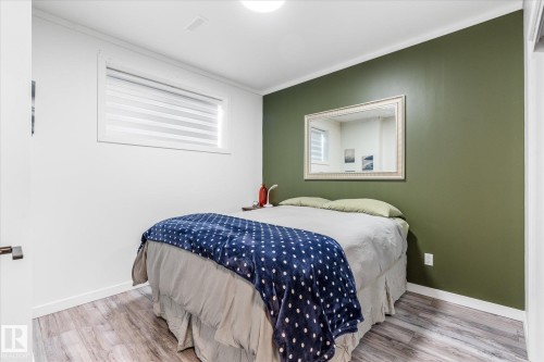 Wood-finish flooring with white baseboards - 9 Dillingham Avenue, Fort Saskatchewan, AB - Indoor Photo Showing Bedroom
