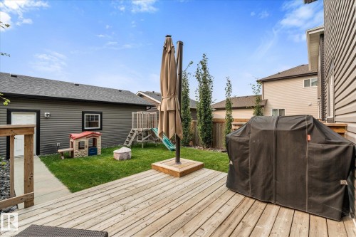 Expansive backyard featuring a wood-finish deck, manicured lawn, and mature trees - 9 Dillingham Avenue, Fort Saskatchewan, AB - Outdoor With Deck Patio Veranda With Exterior