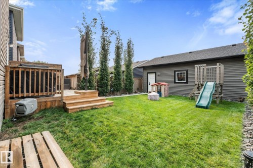 Expansive green lawn with a multi-level wood deck featuring a privacy screen - 9 Dillingham Avenue, Fort Saskatchewan, AB - Outdoor With Deck Patio Veranda With Exterior