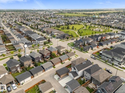 Aerial perspective showcasing a residential development with a central green space, paved streets, and a mix of single-family residences - 9 Dillingham Avenue, Fort Saskatchewan, AB -  With View