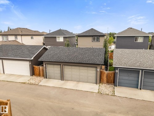 Detached two-car garage with asphalt shingle roof, concrete driveway, and wood fencing - 9 Dillingham Avenue, Fort Saskatchewan, AB - Outdoor With Exterior