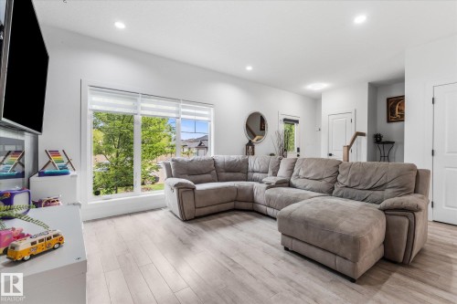 Recessed lighting, wood-finish flooring, and a large window with roller shades - 9 Dillingham Avenue, Fort Saskatchewan, AB - Indoor Photo Showing Living Room