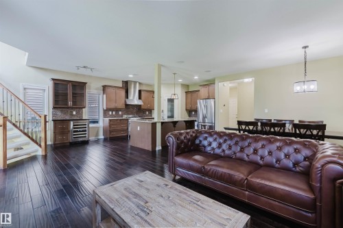 Dark wood-finish flooring throughout the main level - 864 Armitage Wynd Sw, Edmonton, AB - Indoor Photo Showing Other Room