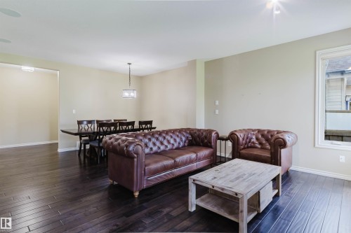 Dark wood-finish flooring throughout, neutral painted walls, and recessed ceiling lighting - 864 Armitage Wynd Sw, Edmonton, AB - Indoor Photo Showing Living Room