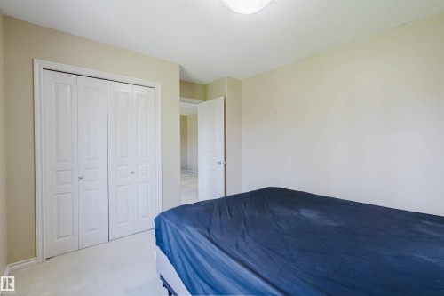 White bi-fold closet doors with round chrome hardware - 864 Armitage Wynd Sw, Edmonton, AB - Indoor Photo Showing Bedroom