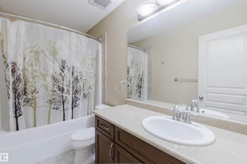 Built-in vanity with a light-colored countertop, undermount sink, and polished chrome faucet - 864 Armitage Wynd Sw, Edmonton, AB - Indoor Photo Showing Bathroom