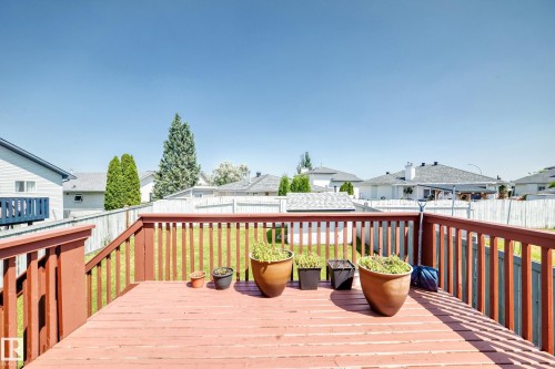 Expansive wood deck with wood railings overlooking a fenced backyard with a manicured lawn - 16227 64 Street Nw, Edmonton, AB - Outdoor With Deck Patio Veranda With Exterior