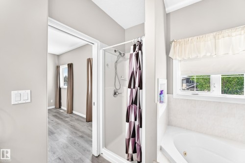 Glass-enclosed shower with a chrome shower head, a built-in alcove, and a soaking tub - 16227 64 Street Nw, Edmonton, AB - Indoor Photo Showing Bathroom