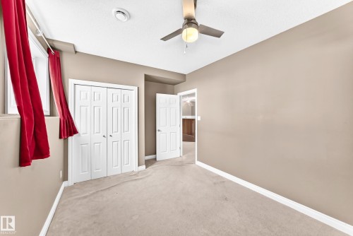 Neutral-toned walls, ceiling fan with integrated lighting, and light-toned carpeting - 16227 64 Street Nw, Edmonton, AB - Indoor Photo Showing Other Room