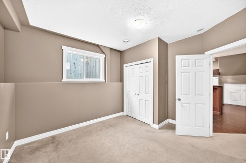Window with white trim, wall-to-wall carpeting, bi-fold closet doors, white paneled door, and recessed lighting - 16227 64 Street Nw, Edmonton, AB - Indoor