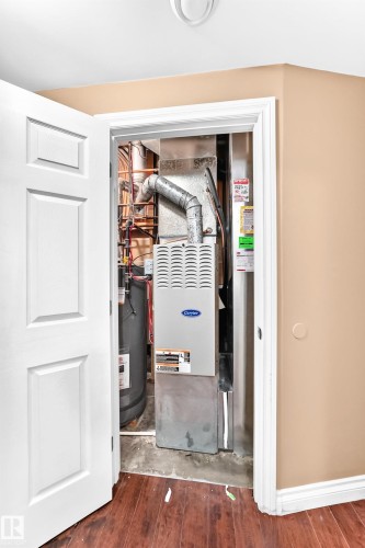 Carrier furnace unit and water heater within utility closet - 16227 64 Street Nw, Edmonton, AB - Indoor