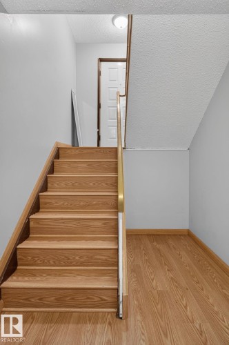 Staircase featuring wood-finish treads and risers, complemented by a wood-finish handrail - 10644 158 Avenue Nw, Edmonton, AB - Indoor Photo Showing Other Room