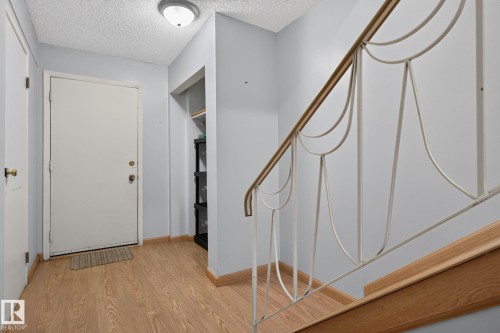 Entryway featuring wood-finish flooring, a flush-mount ceiling light, and a built-in shelving alcove - 10644 158 Avenue Nw, Edmonton, AB - Indoor Photo Showing Other Room