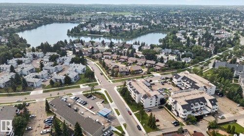 Aerial perspective featuring a residential area with a prominent body of water, extensive green spaces, and dense tree coverage - 10644 158 Avenue Nw, Edmonton, AB - Outdoor With Body Of Water With View
