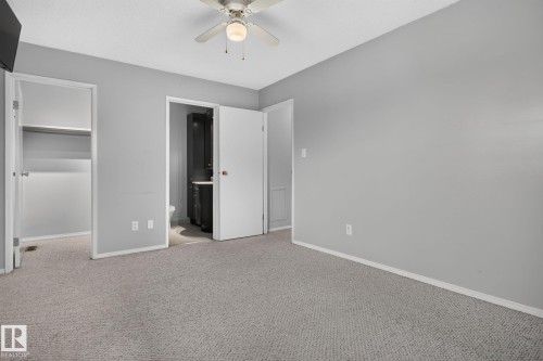 Carpeted interior space with light gray walls, white trim, and a ceiling fan - 10644 158 Avenue Nw, Edmonton, AB - Indoor Photo Showing Other Room