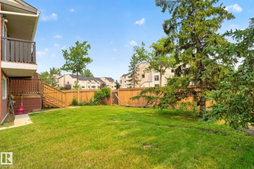 Expansive backyard with a manicured lawn, established perimeter trees, and a wooden privacy fence - 10644 158 Avenue Nw, Edmonton, AB - Outdoor With Balcony