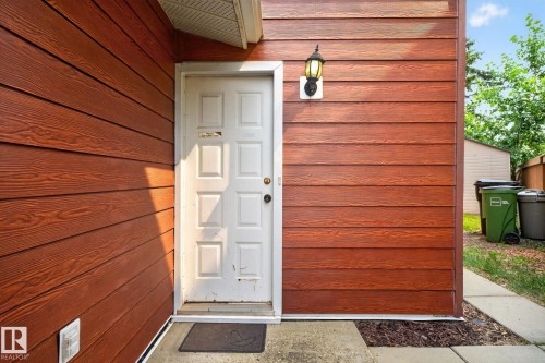 Brown horizontal siding with a white paneled entry door - 10644 158 Avenue Nw, Edmonton, AB - Outdoor With Exterior