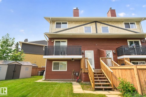 Multi-level townhome featuring a red siding facade and a light stucco upper level - 10644 158 Avenue Nw, Edmonton, AB - Outdoor With Balcony With Exterior