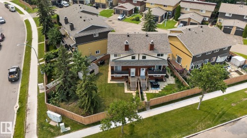 Semi-detached residence featuring a gabled roofline, multiple chimneys, and front-facing balconies with wooden railings - 10644 158 Avenue Nw, Edmonton, AB - Outdoor With View