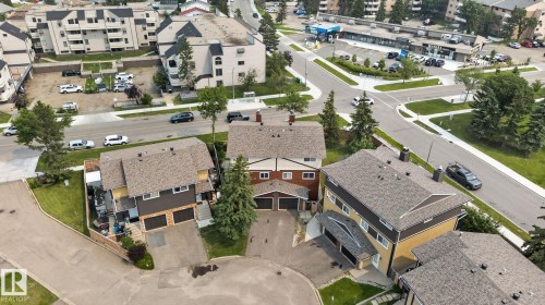 Three multi-level properties featuring brown and yellow siding, shingled roofing, and attached garages - 10644 158 Avenue Nw, Edmonton, AB - Outdoor With View