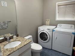 Vanity with granite countertop, integrated sink, and mosaic tile backsplash - 