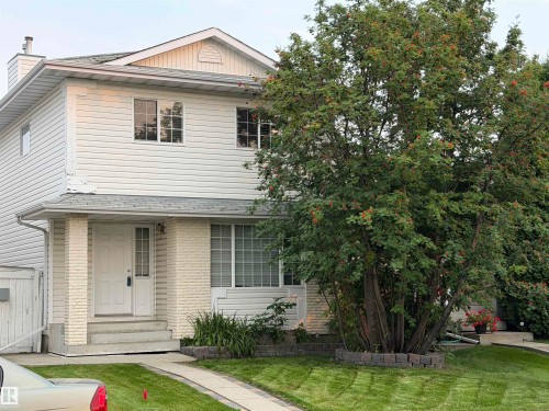 Two-story residential structure featuring white siding and a prominent front entrance with white brick accents - 1535 80A Street Nw, Edmonton, AB - Outdoor