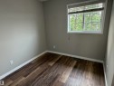 Wood-finish flooring, neutral wall tones, white trim, and a window with blinds - 1535 80A Street Nw, Edmonton, AB  - Indoor Photo Showing Other Room 