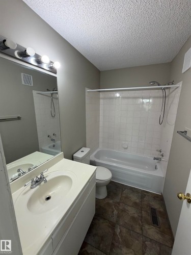 Vanity with integrated sink, chrome faucet, and overhead lighting - 1535 80A Street Nw, Edmonton, AB - Indoor Photo Showing Bathroom