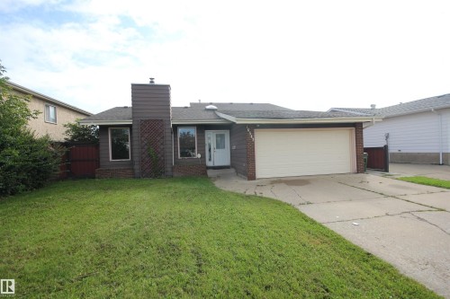 Single-story exterior with a two-car garage, brick facade detailing, and a prominent chimney feature - 16547 113 Street Nw, Edmonton, AB - Outdoor