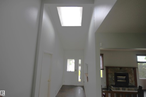 Skylight illuminating a high-ceiling entryway with a white door - 16547 113 Street Nw, Edmonton, AB - Indoor Photo Showing Other Room