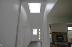 Skylight illuminating a high-ceiling entryway with a white door - 