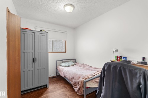 Wood-finish flooring with white walls and a ceiling-mounted light fixture - 8723 81 Avenue Nw, Edmonton, AB - Indoor Photo Showing Bedroom