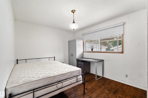 Hardwood-style flooring, white walls, and a window with a roller shade - 8723 81 Avenue Nw, Edmonton, AB - Indoor Photo Showing Bedroom