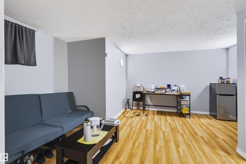Wood-finish flooring throughout, light gray wall finishes, textured ceiling, and white trim - 8723 81 Avenue Nw, Edmonton, AB - Indoor