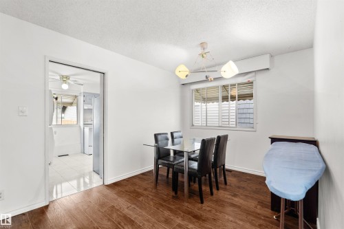 Wood-finish flooring throughout, white painted walls, and a window with horizontal blinds - 8723 81 Avenue Nw, Edmonton, AB - Indoor Photo Showing Dining Room