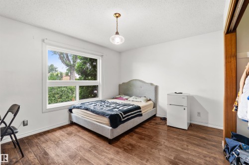 Room featuring wood-finish flooring, white walls, and a large window - 8723 81 Avenue Nw, Edmonton, AB - Indoor Photo Showing Bedroom