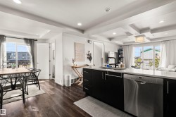 Kitchen featuring dark wood-finish flooring, recessed lighting, and a tray ceiling - 