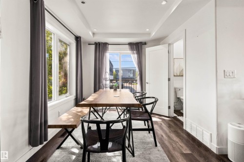 White walls with tray ceiling, dark wood-finish flooring, recessed lighting, and a sliding glass door - 15713 102 Avenue Nw, Edmonton, AB - Indoor Photo Showing Dining Room