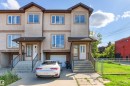 Stucco exterior with contrasting trim, multiple windows, covered entryways, and integrated garages - 15713 102 Avenue Nw, Edmonton, AB  - Outdoor With Facade 