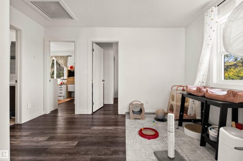 Wood-finish flooring, white walls, and a window with natural light - 15713 102 Avenue Nw, Edmonton, AB - Indoor Photo Showing Other Room