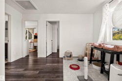 Wood-finish flooring, white walls, and a window with natural light - 