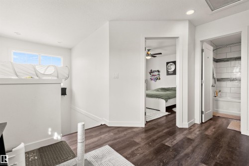 Wood-finish flooring, recessed lighting, and white interior doors - 15713 102 Avenue Nw, Edmonton, AB - Indoor Photo Showing Other Room