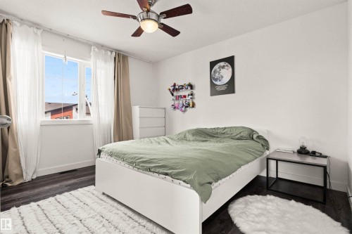 Wood-finish flooring, white walls, and a ceiling fan with integrated lighting - 15713 102 Avenue Nw, Edmonton, AB - Indoor Photo Showing Bedroom
